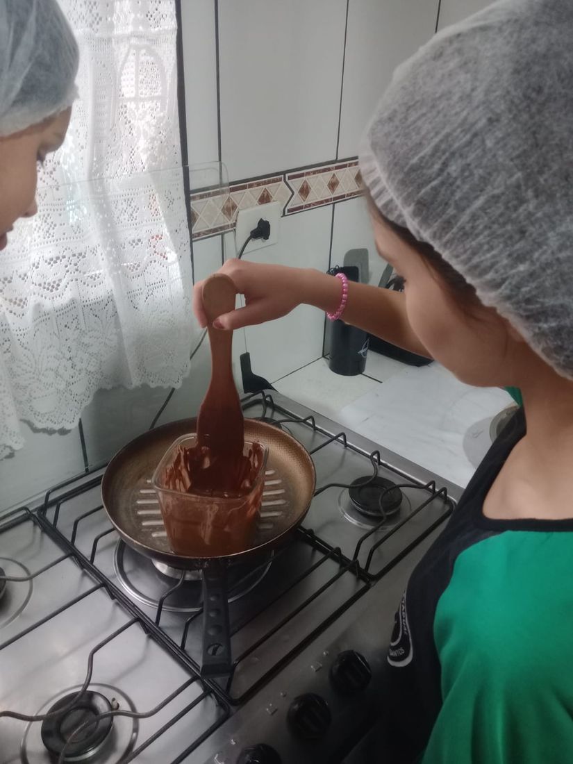 Adolescente mexendo o chocolate derretido em banho-maria